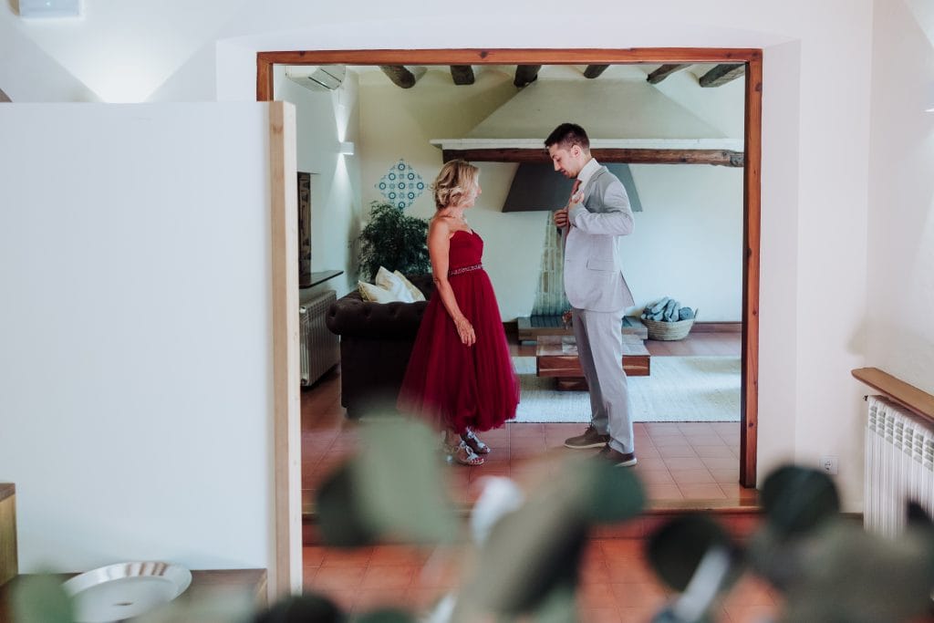Boda única con novia en vestido rojo y novio en sala moderna y acogedora.