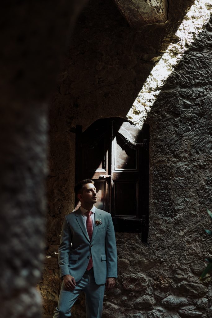 Boda en una cueva natural con ambiente íntimo y romántico. Novio en traje azul, rodeado de paredes d.