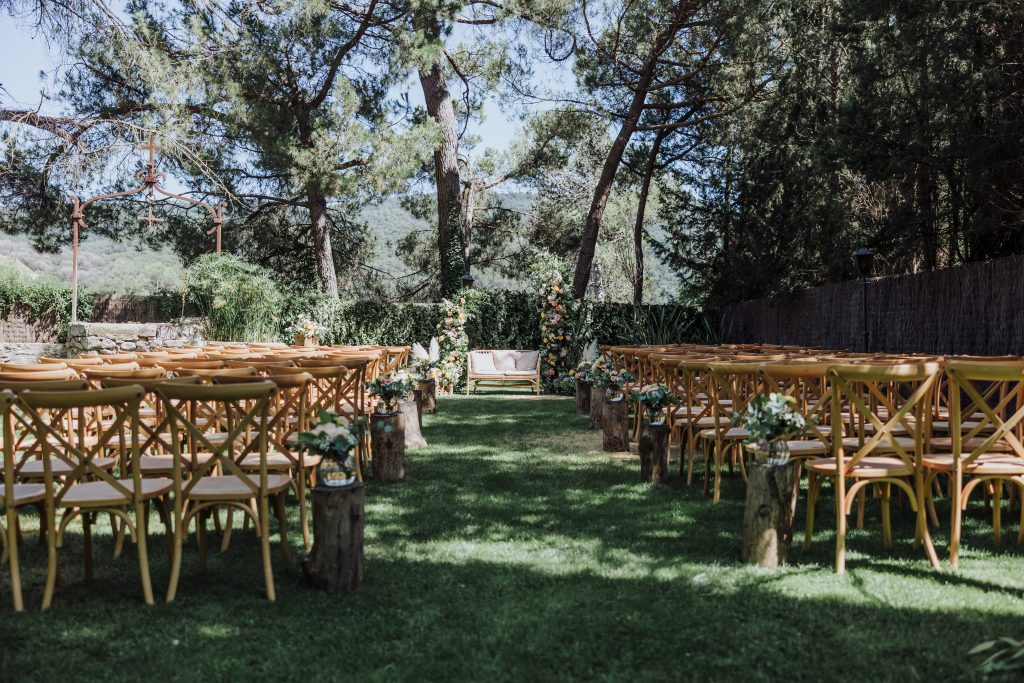 Boda en jardín al aire libre con decoración natural y mesas elegantes.