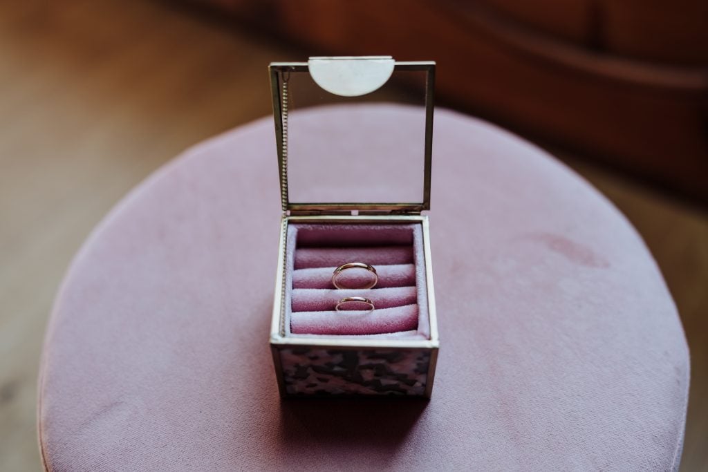 Anillos de boda en caja de terciopelo rosa para ceremonia de matrimonio.