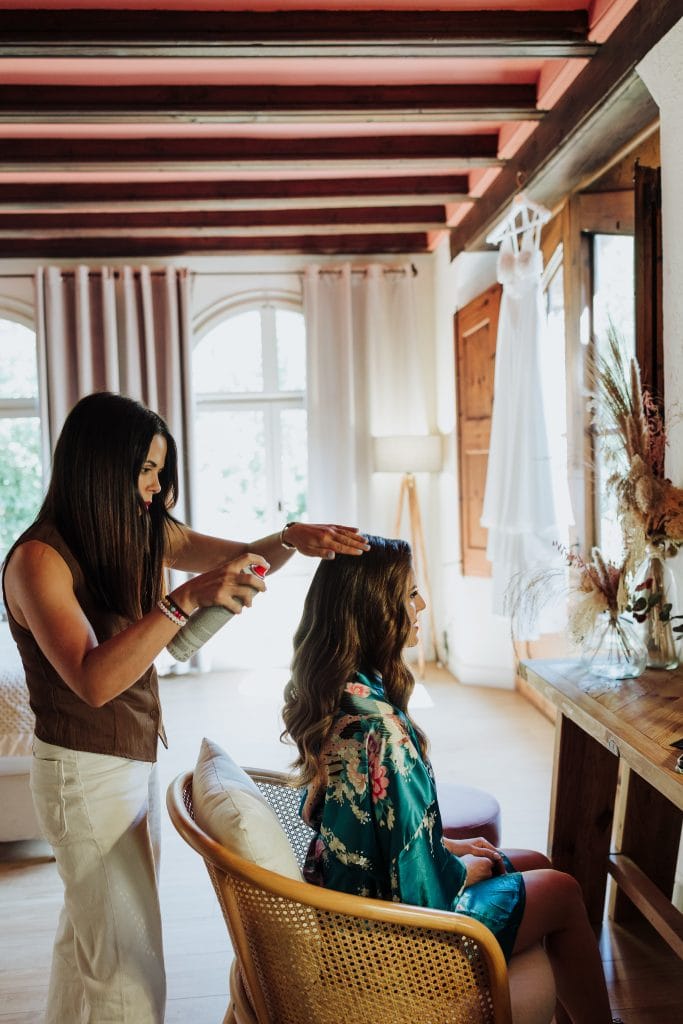 Maquillaje y peinado para novia en un entorno acogedor.