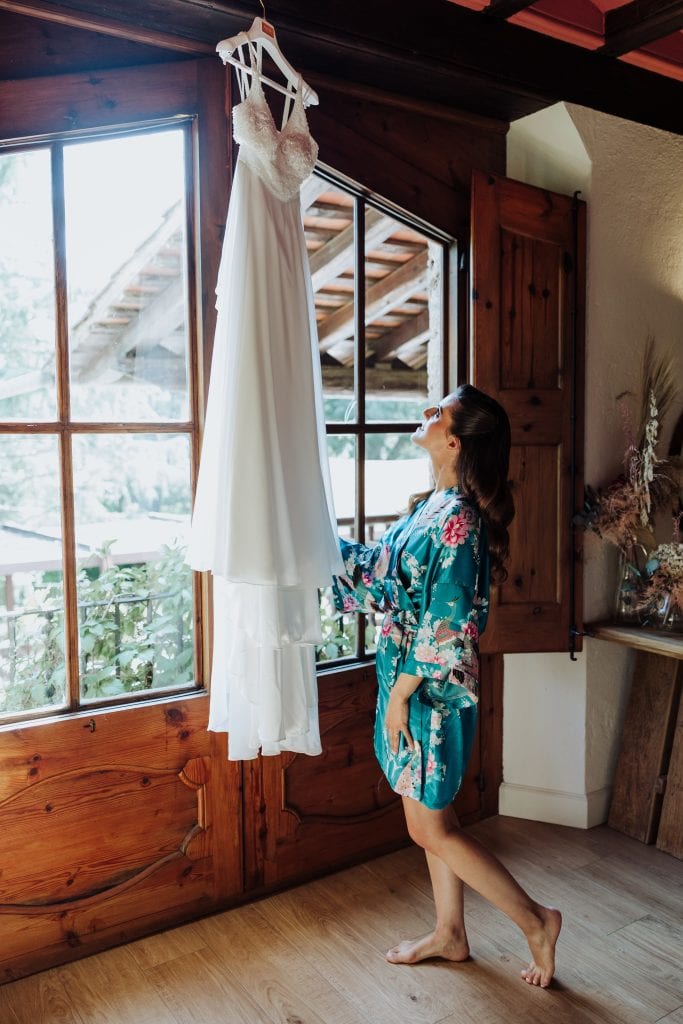 Vestido de novia largo colgado junto a la ventana.