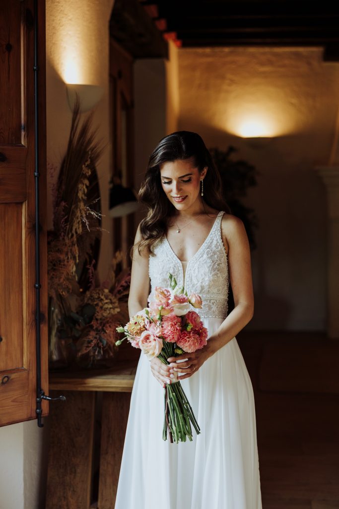 Boda única y especial en Atypical Wedding, con novia con vestido blanco y ramo de flores en ambiente.