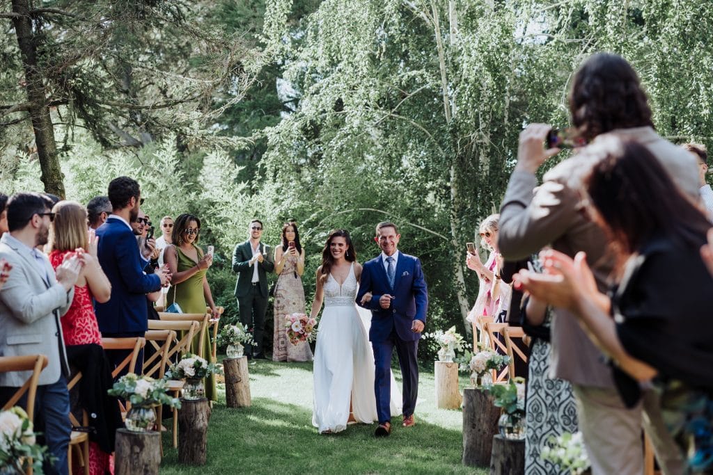 Boda al aire libre en un entorno natural con invitados celebrando la unión de la pareja. Escenario h.
