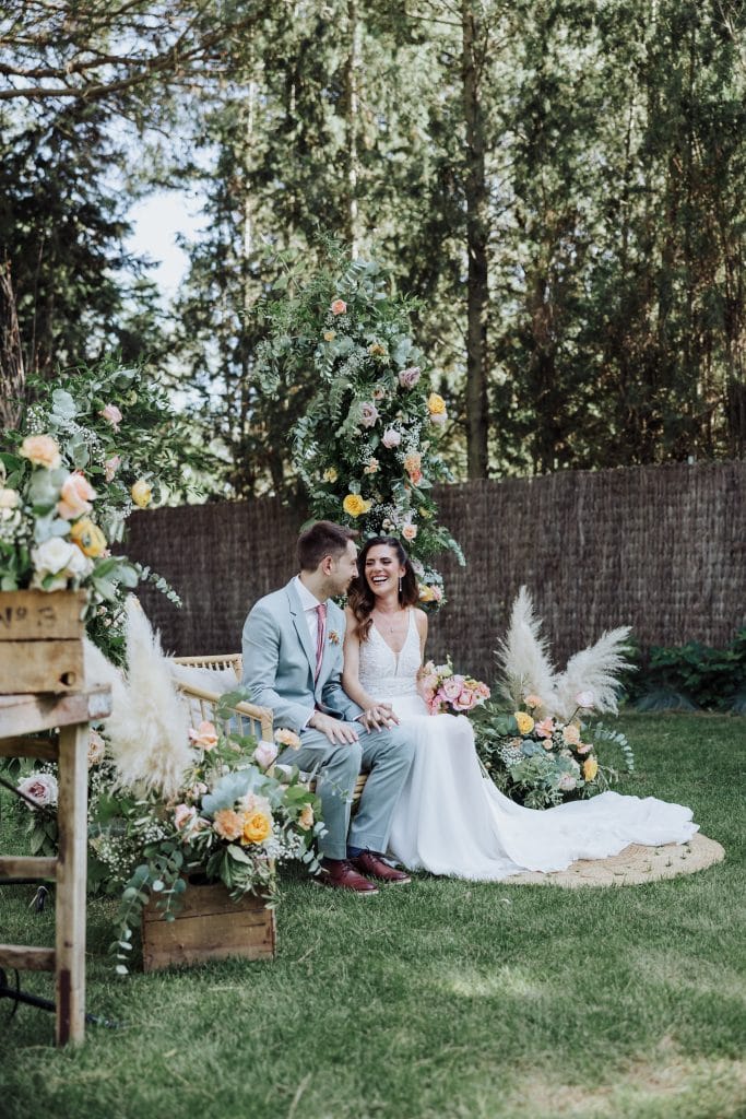 Boda en un entorno natural con decoración floral y pareja feliz en ceremonia al aire libre.
