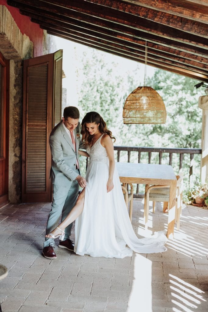 Boda única en entorno rústico con pareja en vestido de novia y traje de novio en terraza con madera.