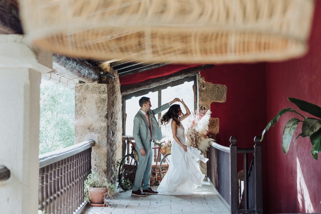 Boda única en un entorno rústico y acogedor con pareja en un balcón con vistas naturales.