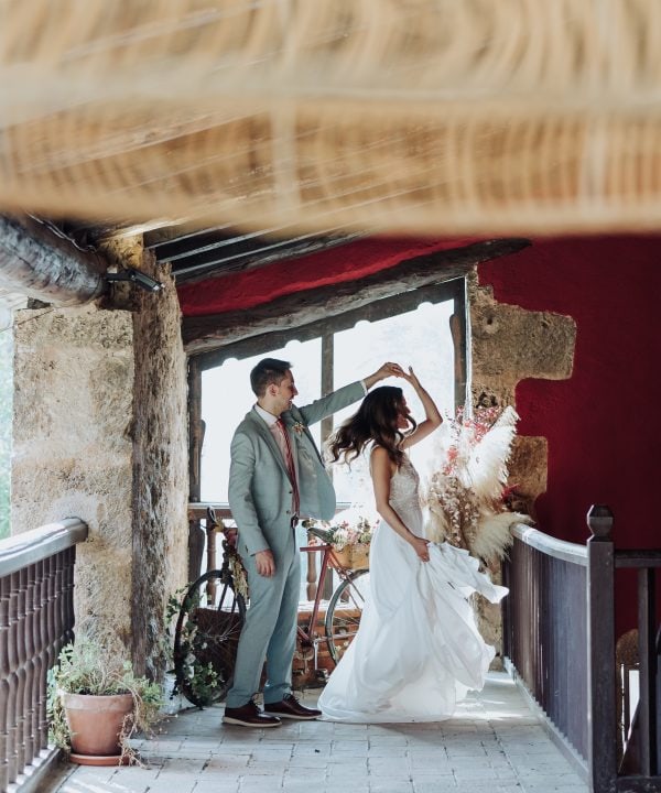 Boda única en un entorno rústico y acogedor con pareja en un balcón con vistas naturales.