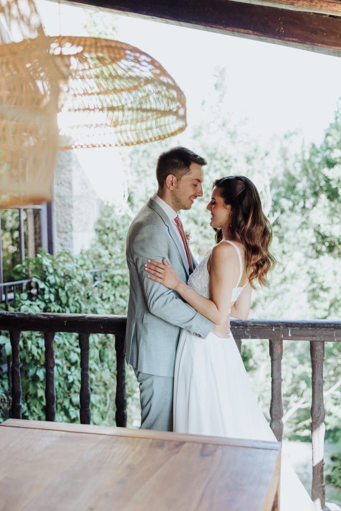 Boda en entorno natural con pareja en un momento romántico en una terraza al aire libre.