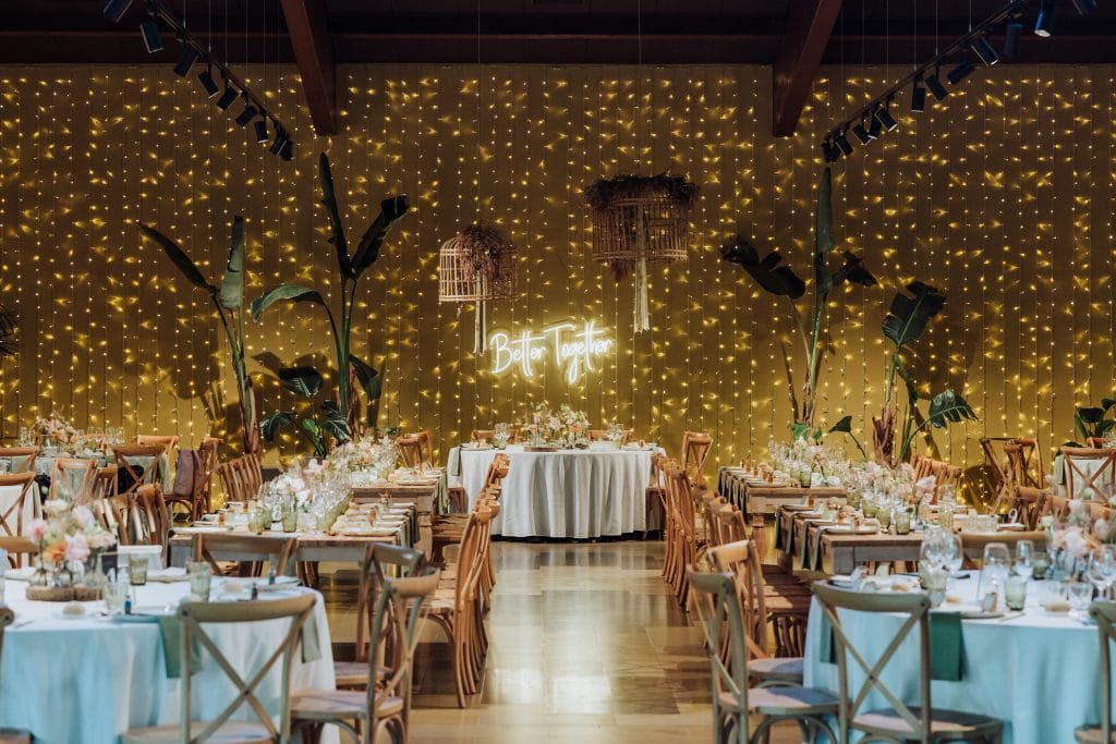 Decoración de boda con luces y plantas tropicales en Atypical Wedding.