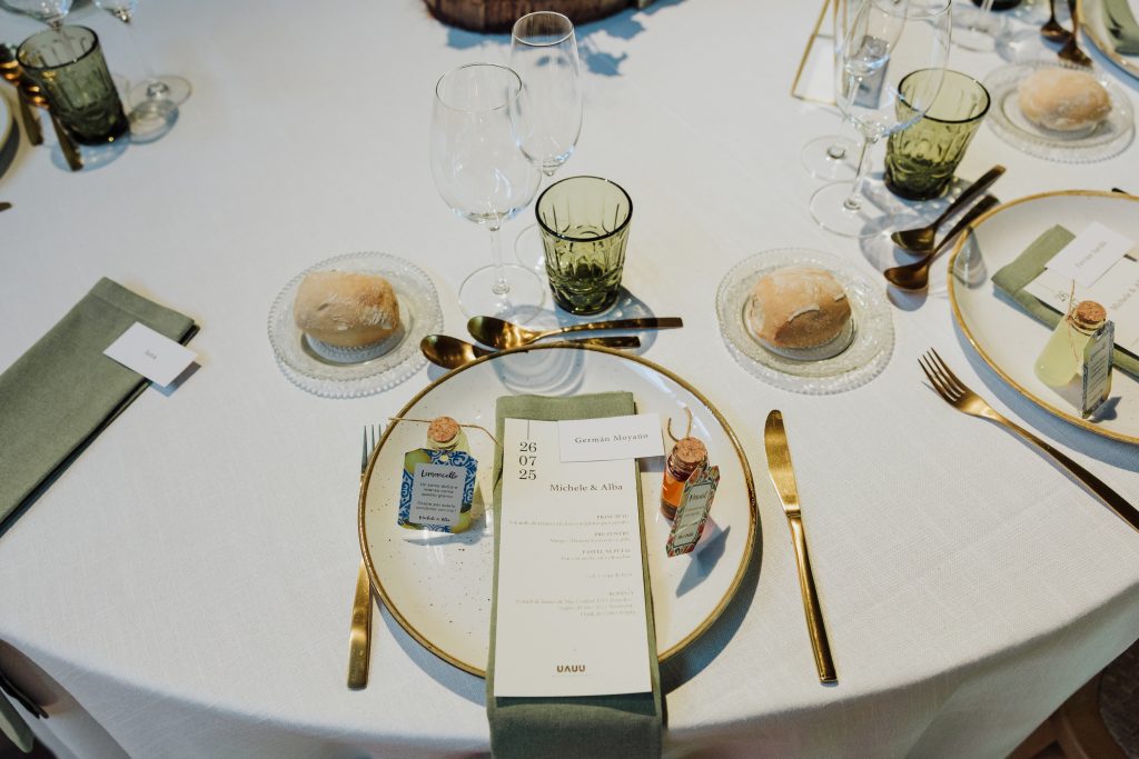 Mesa decorada con cristalería y vajilla elegante para boda.