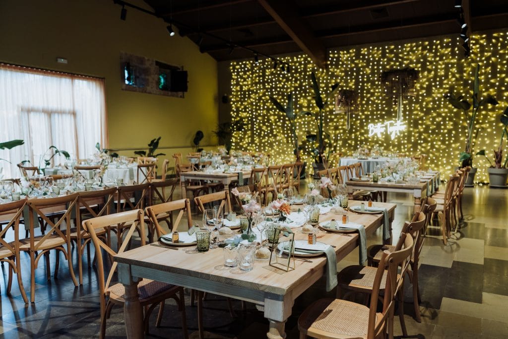Decoración de boda con luces cálidas y mesas elegantes.