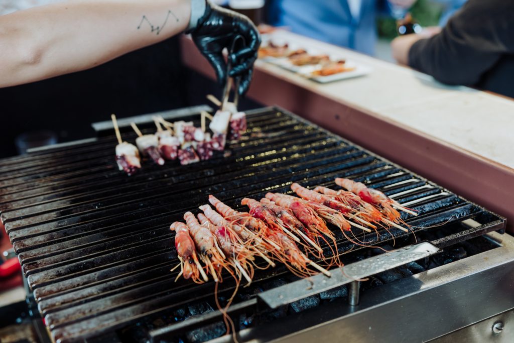 Barbacoa de mariscos y carne en boda al aire libre.