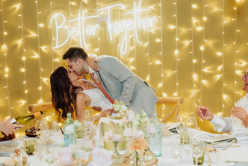 Boda con pareja besándose en una celebración íntima y romántica.