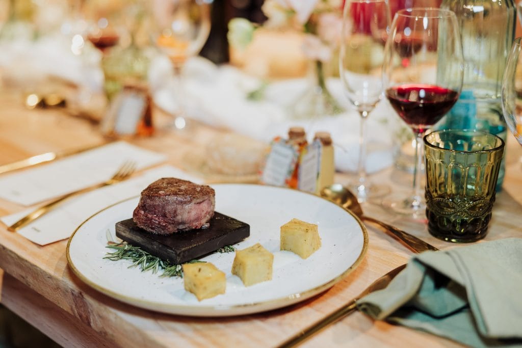 Cena gourmet en boda atípica con vino tinto y presentación elegante.