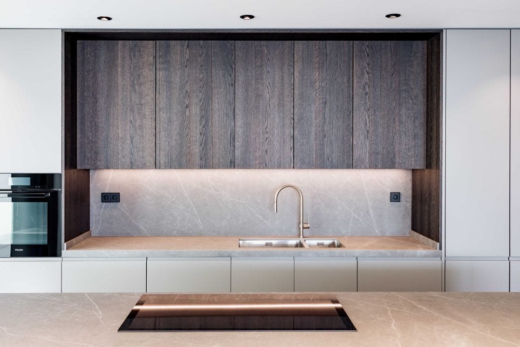 Cocina moderna y minimalista con encimera de piedra natural y armarios blancos elegantes. Diseño fun.