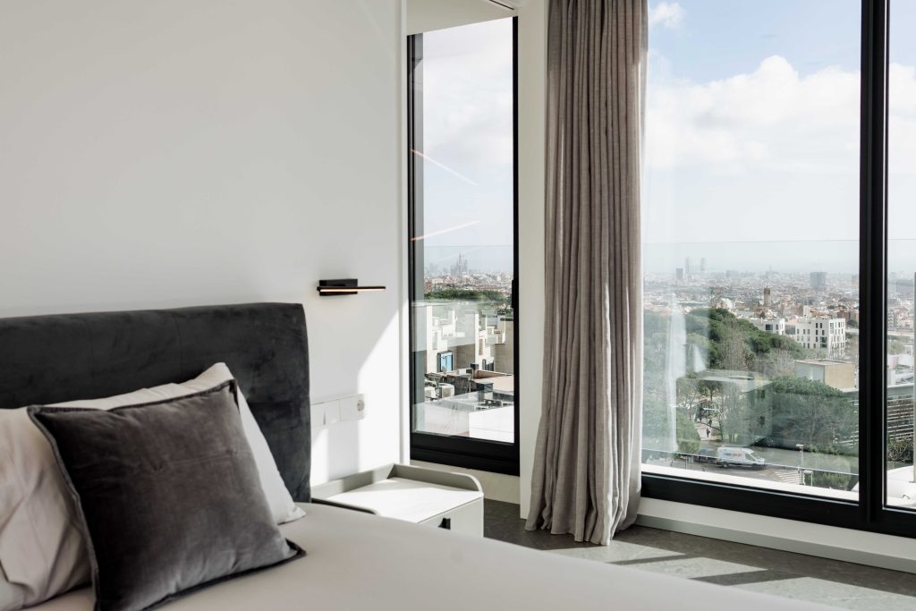 Habitación moderna con grandes ventanas y vistas panorámicas en una boda atípica.