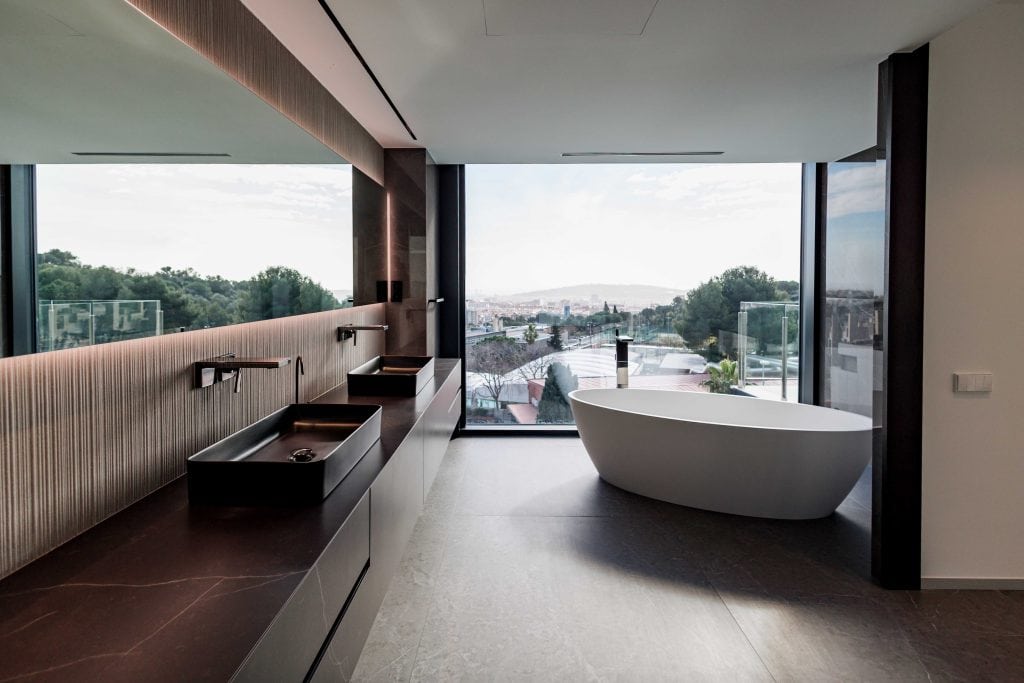 Baño moderno con bañera independiente y vista panorámica de la ciudad.