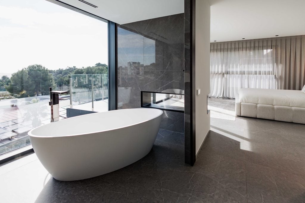 Bañera de diseño en habitación moderna con vistas panorámicas y gran luminosidad.