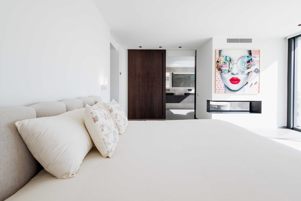 Habitación de hotel moderna con decoración minimalista y arte contemporáneo en la pared.