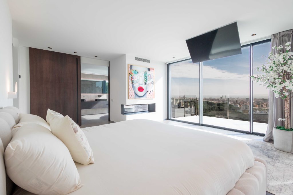 Habitación elegante con grandes ventanas y vistas a la ciudad, decorada con estilo minimalista y det.