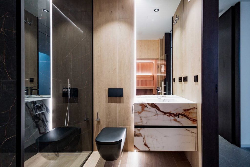 Baño contemporáneo con ducha y mobiliario de diseño en tonos neutros.
