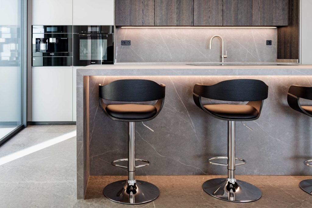 Barra de cocina moderna con taburetes y diseño elegante.